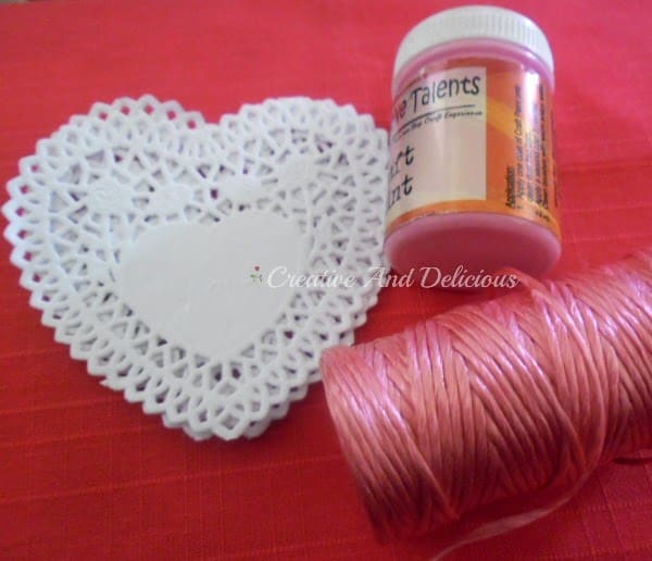 Craft supplies needed to make a valentines day doily banner and vase