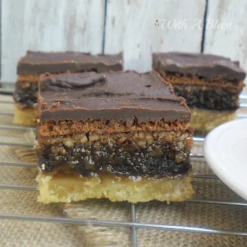 Gooey Chocolate Peanut Bars ~ Layers of pure delight ~ cookie crust with a gooey chocolate/peanut filling and topped with a rich chocolate icing #SweetTreats #PartySnacks #Desserts #PeanutBars www.WithABlast.net Gooey Chocolate Peanut Bars ~ Layers of pure delight ~ cookie crust with a gooey chocolate/peanut filling and topped with a rich chocolate icing #SweetTreats #PartySnacks #Desserts #PeanutBars www.WithABlast.net