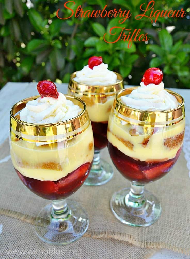 Strawberry Liqueur Trifles ~ Boozy Jello made from fresh Fruit Juice, combined with Custard, Strawberries, Swiss Roll slices and topped with Cream and a Cherry make these Individual (or one huge!) trifles a winner each and every time #Trifle #IndividualTrifles #TrifleRecipes #BoozyTrifleRecipe
