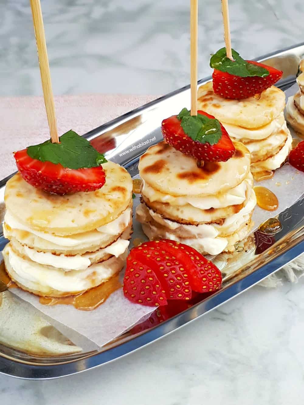 Deliciously Mascarpone Filled Mini Pancakes Stacks are perfect for a special breakfast, brunch or even a sweet treat. Perfect with Strawberries and drizzled with Honey! #PancakeStacks #MiniPancakes #FilledPancakes #BreakfastRecipes #SweetTreatRecipes